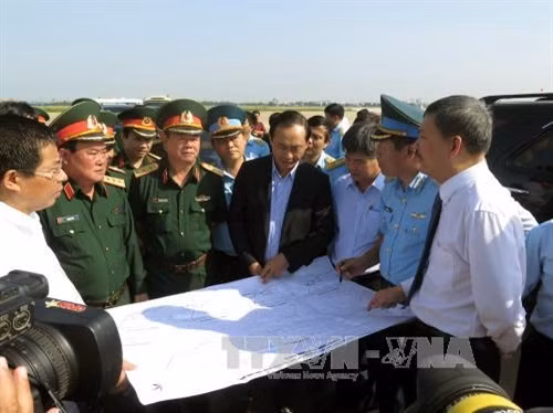 Lãnh đạo Bộ Quốc phòng và Bộ Giao thông Vận tải xem bản đồ sân đỗ quân sự tại Cảng hàng không Quốc tế Tân Sơn Nhất. Ảnh: Hoàng Hải-TTXVN