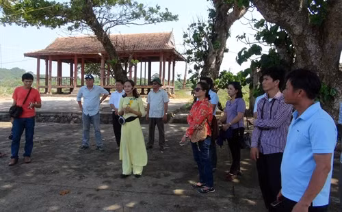 Đoàn tham quan nghe hướng dẫn viên giới thiệu về địa danh Bến Nghè, địa điểm cập thuyền của dân quân tiếp tế cho đảo trong những ngày kháng chiến chống giặc.