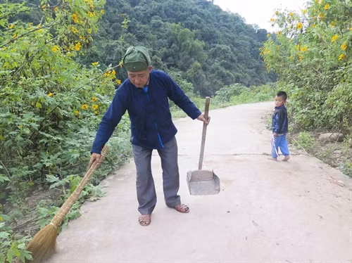 Ông Lỳ Xuyến Phù đang làm vệ sinh đường bản.