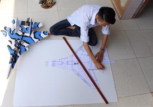 Công đoạn cắt xốp làm vỏ mô hình máy bay. Ảnh: Tùng Lâm- TTXVN