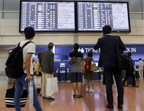 Hành khách kiểm tra thông tin chuyến bay tại sân bay quốc tế Tokyo ở Haneda, thủ đô Tokyo, Nhật Bản . EPA/TTXVN