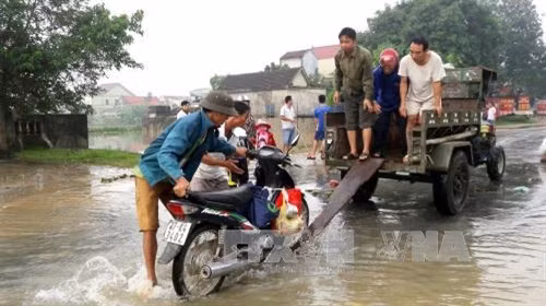 Người dân ở huyện Yên Thành (Nghệ An) đi tránh lũ. Ảnh: TTXVN phát