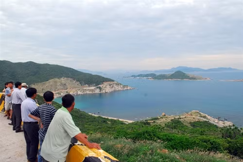 Khách tham quan dừng chân ngắm bờ biển thuộc xã Vĩnh Hải, huyện Ninh Hải, tỉnh Ninh Thuận nhìn về phía đảo Bình Hưng.