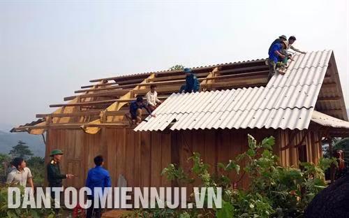 Chiến sĩ Đoàn Kinh tế - Quốc phòng 4 giúp đồng bào dân tộc ở bản Thẳm Hím, xã Nậm Càn, huyện Kỳ Sơn làm nhà. Ảnh: Trần Việt