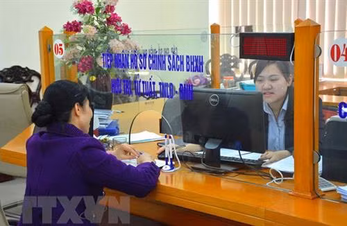 Các cán bộ công tại phòng giao dịch một cửa tại Bảo hiểm xã hội tỉnh Nam Định - Ảnh TTXVN