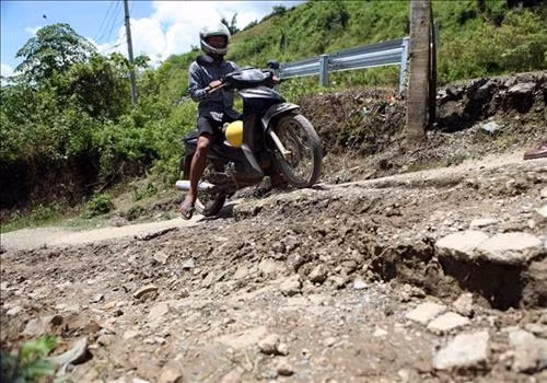 Vết nứt của con đường dẫn vào bản Nà Phạ ngày một lớn, khiến cho người dân tham giao thông gặp nhiều khó khăn. Ảnh: Quý Trung – TTXVN
