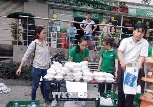 Nhân viên Co.opFood Carina chuẩn bị các phần cơm hỗ trợ người dân gặp nạn. Ảnh: Mỹ Phương –TTXVN
