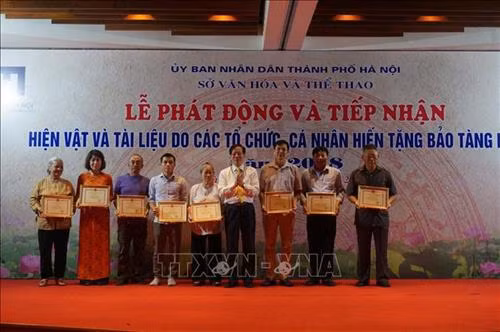 Lãnh đạo Sở Văn hóa và Thể thao Hà Nội trao giấy khen cho các cá nhân hiến tặng tài liệu, hiện vật cho Bảo tàng Hà Nội. Ảnh: Đinh Thuận - TTXVN