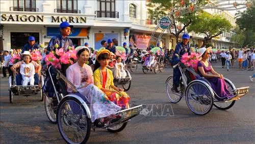 Đoàn rước thu hút du khách trong và ngoài nước tham gia. Ảnh: Tường Vi - TTXVN