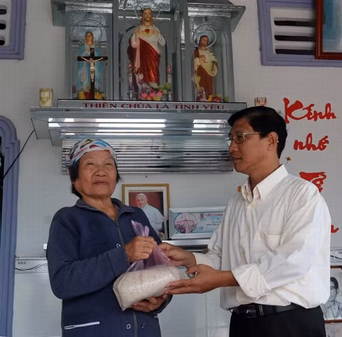 Linh mục Nguyễn Văn Lý tặng gạo cho người già neo đơn.