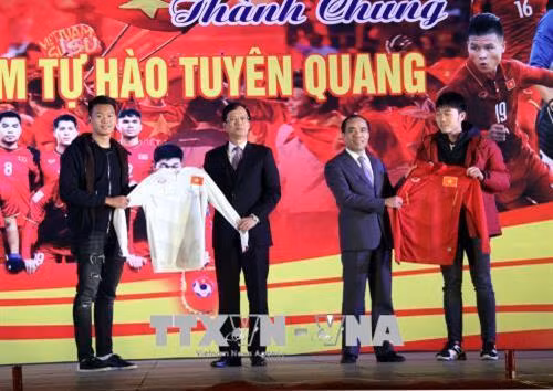 Hai tuyển thủ U23 Lương Xuân Trường, Nguyễn Thành Trung tặng chiếc áo đấu có chữ ký cho lãnh đạo tỉnh Tuyên Quang. Ảnh: Quang Cường – TTXVN
