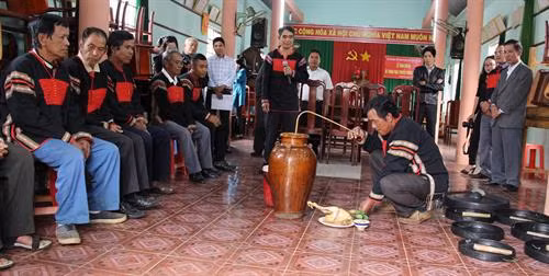 Rót rượu cần ra chén, cùng gà luộc để mời thần linh về chứng kiến.
