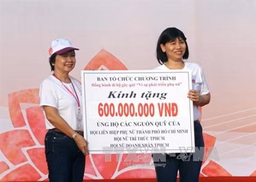 Ban tổ chức trao tượng trưng số tiền ủng hộ quỹ "Nữ sinh nghèo hiếu học và phụ nữ khó khăn" cho Hội Phụ nữ Thành phố Hồ Chí Minh. Ảnh: Phương Vy-TTXVN