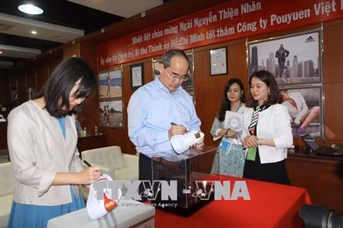 Bí thư Thành ủy Thành phố Hồ Chí Minh Nguyễn Thiện Nhân và bà Thái Bội Quân, Chủ tịch kiêm Tổng Giám đốc điều hành Tập đoàn Pou Yuen ký lưu niệm lên sản phẩm của Công ty TNHH Pou Yuen Việt Nam. Ảnh: Thanh Vũ-TTXVN