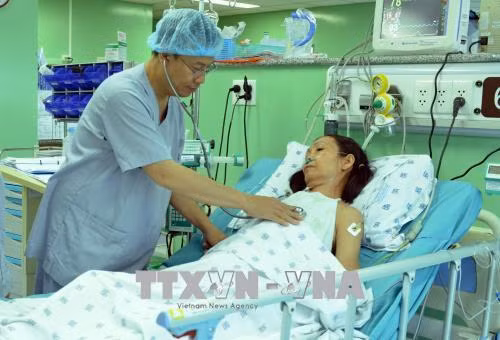 PGS.TS.BS Nguyễn Hoàng Định, Phó Giám đốc Trung tâm tim mạch, Trưởng khoa Phẫu thuật tim mạch Bệnh viện Đại học Y Dược Thành phố Hồ Chí Minh, thăm khám cho bệnh nhân sau khi phẫu thuật thay van tim bằng kỹ thuật Ozaki. Ảnh: Phương Vy-TTXVN
