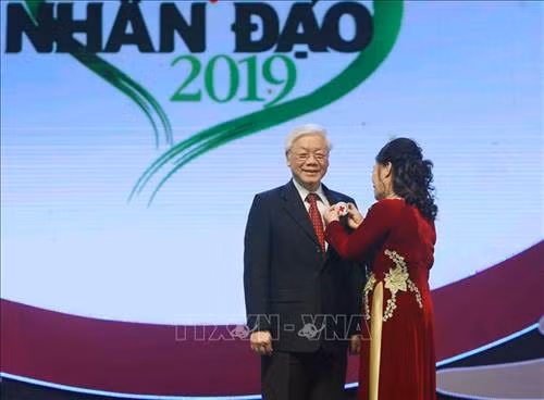 Chủ tịch Hội Chữ thập đỏ Việt Nam Nguyễn Thị Xuân Thu gắn Huy hiệu và chúc mừng Tổng Bí thư, Chủ tịch nước Nguyễn Phú Trọng là Chủ tịch danh dự Hội Chữ thập đỏ Việt Nam. Ảnh: Thanh Tùng-TTXVN
