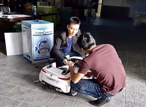 Thạc sỹ Huỳnh Phúc Minh (áo đen) chế tạo robot Tâm An. Ảnh: Mai Trang-TTXVN