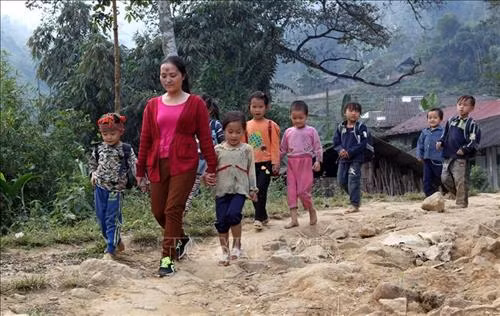 Sau giờ học, các cô giáo chủ nhiệm phải đưa các em học sinh qua cây cầu tạm. Ảnh: Quốc Khánh - TTXVN