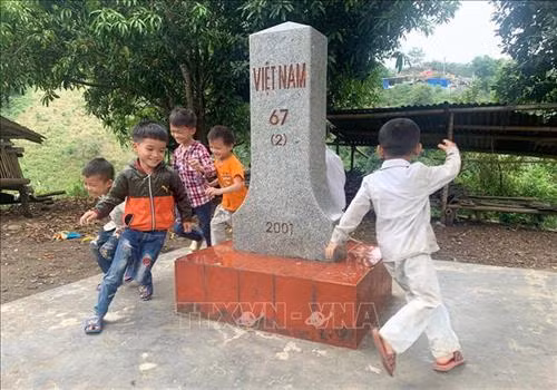Cột mốc lát đá hoa, dọn dẹp sạch sẽ là chỗ vui chơi của các cháu nhỏ trong bản Hùng Pèng. Ảnh: Việt Hoàng - TTXVN