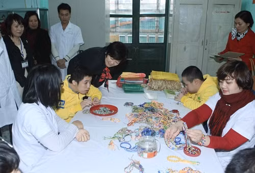 Phu nhân Thủ tướng Nhật Bản Shinzo Abe xem những sản phẩm do người khuyết tật tại Bệnh viện phục hồi chức năng Hà Nội (Làng trẻ em Hoà Bình Thanh Xuân) sản xuất. Ảnh Phạm Kiên- TTXVN