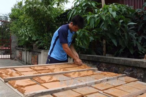 Các mảnh tranh gốm được mang đi phơi trước khi cho vào lò nung. Ảnh: Thanh Thương - TTXVN