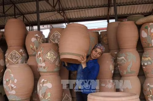 Chum gốm được chuyển vào lò nung. Ảnh: Thanh Thương - TTXVN