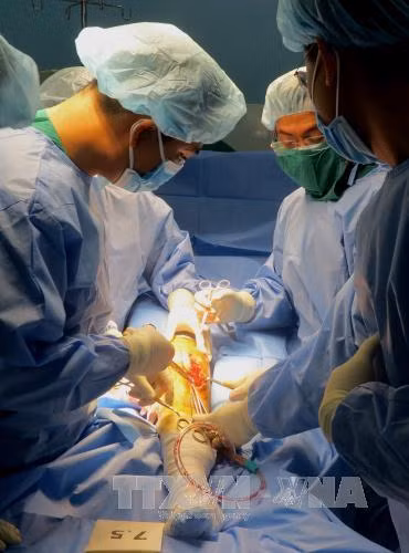 Các bác sĩ Bệnh viện quận Thủ Đức, Thành phố Hồ Chí Minh thực hiện thành công ca phẫu thuật thay khớp gối cho bệnh nhân V.V.C mắc rối loạn đông máu. Ảnh: Phương Vy- TTXVN