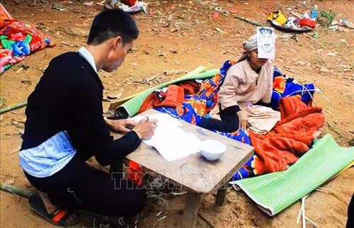 Cậu bé khi rơi xuống từ bồ đài sẽ được các thầy cúng làm lễ coi như vừa được sinh ra từ trong trứng. Ảnh: Phan Tuấn Anh - TTXVN