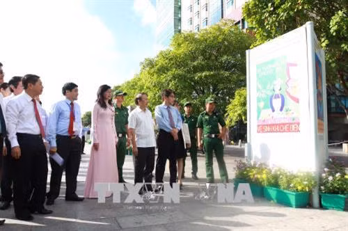 Các đại biểu tham quan triển lãm ảnh. Ảnh: Thanh Vũ-TTXVN