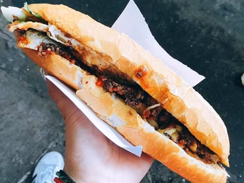 Đây là món ăn hầu hết ai cũng thử khi đến Hội An. Bánh mì có phần nhân cơ bản gồm pate, thịt nướng, chả lụa, rau thơm và nước sốt đặc biệt. Hai tiệm bánh mì nổi tiếng nhất Hội An được báo nước ngoài nhiều lần nhắc đến là bánh mì Phượng và bánh mì Madam Khánh. Giá một ổ bánh mì thường là 20.000 đồng, ổ đặc biệt là 25.000 đồng. Ảnh: Lan Hương