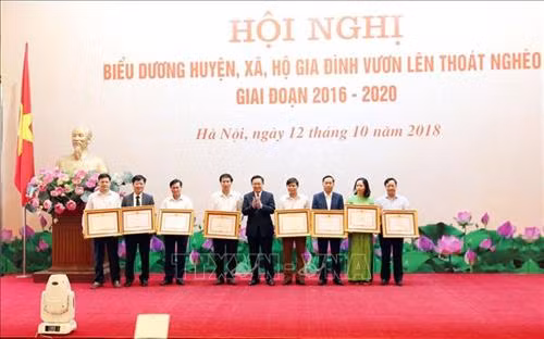 Phó Thủ tướng Chính phủ Vương Đình Huệ, Trưởng Ban Chỉ đạo Trung ương các Chương trình mục tiêu quốc gia tặng Bằng khen của Thủ tướng Chính phủ cho 8 huyện thoát nghèo tại Hội nghị. Ảnh: Anh Tuấn – TTXVN