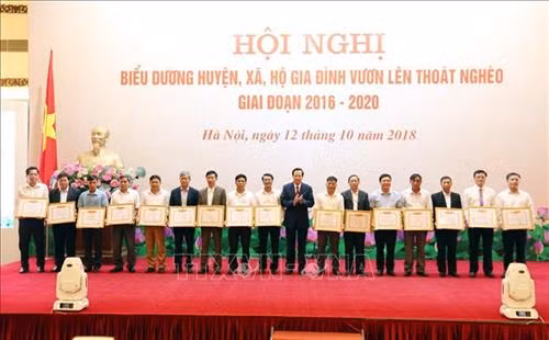 Bộ trưởng Bộ Lao động – Thương binh và Xã hội Đào Ngọc Dung tặng Bằng khen của Bộ trưởng cho 17 xã đặc biệt khó khăn vùng bãi ngang ven biển và hải đảo tại Hội nghị. Ảnh: Anh Tuấn – TTXVN
