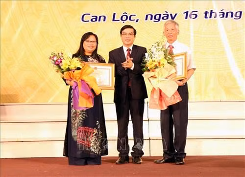 Ông Đặng Quốc Vinh, Phó chủ tịch tỉnh Hà Tĩnh trao bằng khen cho hai cá nhân đã có thành tích trong xây dựng hồ sơ “Hoàng hoa sứ trình đồ”. Ảnh: Công Tường-TTXVN