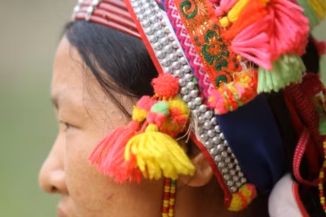 Người La Hủ hay còn gọi là Xá Lá Vàng, Cò Xung, Khù Sung, Khả Quy... hiện có khoảng 10.000 người, sinh sống chủ yếu ở đầu nguồn sông Đà, thuộc huyện Mường Tè, tỉnh Lai Châu. Tuy cuộc sống còn nhiều khó khăn, song đồng bào La Hủ nơi đây vẫn chú trọng gìn giữ bản sắc văn hóa truyền thống, nhất là phụ nữ mặc áo dài tà đen làm nổi bật vóc dáng. Phơ cơ zỡ – tiếng La Hủ có nghĩa là áo dài. Người La Hủ ở Mường Tè thường mặc áo dài tà đen. Các họa tiết, hoa văn... trên mỗi bộ trang phục phụ nữ La Hủ nói lên sự gắn bó giữa cơ thể con người trong sự vận động của cuộc sống với thiên nhiên. Áo dài của người La Hủ ngoài việc mặc ôm sát làm nổi bật đường cong của cơ thể người phụ nữ, còn đẹp ở cách phối màu sắc, cách trang trí và kỳ công của người làm. Mỗi người con gái La Hủ khi đến tuổi thành niên đều tự ý thức may cho mình một chiếc áo dài. Con gái La Hủ thường mặc loại áo cánh tay có nhiều sắc đỏ thể hiện sức sống tươi trẻ và niềm tin yêu cuộc sống. Do hoàn toàn được làm thủ công, nên thời gian để người La Hủ may một chiếc áo dài có khi mất cả tháng mới xong. Duyên dáng thiếu nữ dân tộc La Hủ. Cao nhất trên đầu là vành khăn trang trí với 5 màu sắc. Khăn quấn đầu chủ yếu được làm bằng vải đủ màu và hạt cườm rủ xuống, tạo nét khả ái cho khuôn mặt của người phụ nữ. Để có được bộ trang phục, khăn đội đầu đẹp, đòi hỏi ý tưởng sáng tạo nghệ thuật của người làm. Màu sắc chủ đạo được phối ở cánh tay và điểm xuyết bạc trắng ở thân áo. Làm đẹp cho thân áo còn có sự kết hợp của các hoa văn làm bằng nhôm hình tròn, hình tam giác. Một chiếc áo đẹp còn ở cách trang trí, bài trí những đường diềm tỉ mỉ trên thân áo, tay áo nổi bật lên trên nền vải đen với nhiều màu chỉ đen, đỏ, vàng... May tay áo là công đoạn chiếm nhiều thời gian nhất, có thể tận dụng vải cũ làm lớp lót bên trong, phía ngoài được may ngược. Một ngày với người phụ nữ La Hủ được bắt đầu bằng việc vận trang phục và công đoạn lâu nhất là bện tóc, bọc bằng sợi dây vải màu hồng. Mũ đội đầu Người La Hủ khâu ngực áo rất cẩn thận, đây là công đoạn tách rời những đường viền xếp chồng lên nhau của các loại vải. Việc này không chỉ thể hiện sự khéo léo của những người phụ nữ, mà còn là một trong những nét đẹp trong văn hóa truyền thống của người La Hủ. Vòng quấn đầu được làm từ cây song, mây trên rừng và được điểm tô bằng những chiếc ghim nhôm trang trí. Trang phục truyền thống dân tộc La Hủ đang có nguy cơ mai một, do những thách thức từ điều kiện kinh tế - xã hội.. ...Và việc đồng hóa giữa các dân tộc về phong tục, trang phục. Lớp trẻ dân tộc La Hủ ngày nay thường tự ti khi mặc áo dài dân tộc mình.