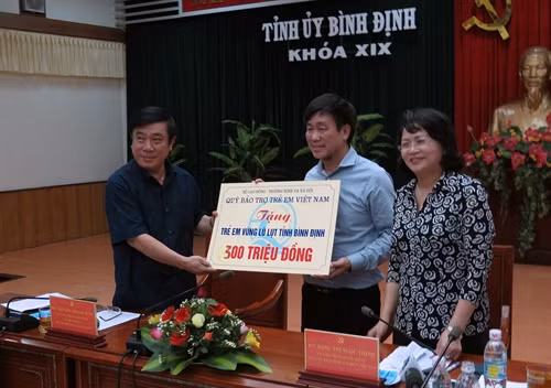 Chiều 20-12, Đoàn công tác Văn phòng Chủ tịch nước do Phó Chủ tịch nước Đặng Thị Ngọc Thịnh dẫn đầu, đã tới thăm và tặng quà người dân vùng rốn lũ xã Phước Hòa, huyện Tuy Phước, tỉnh Bình Định. Phó Chủ tịch nước đã tặng 20 suất quà cho người dân huyện Tuy Phước bị sập nhà do lũ lụt, mỗi suất trị giá 10 triệu đồng và trao tặng cho trẻ em vùng lũ Bình Định 300 triệu đồng để mua sách vở, giúp các em tiếp tục đến trường. Trong ảnh: Phó Chủ tịch nước Đặng Thị Ngọc Thịnh trao tặng cho trẻ em vùng lũ Bình Định 300 triệu đồng để mua sách vở. Ảnh: Viết Ý-TTXVN