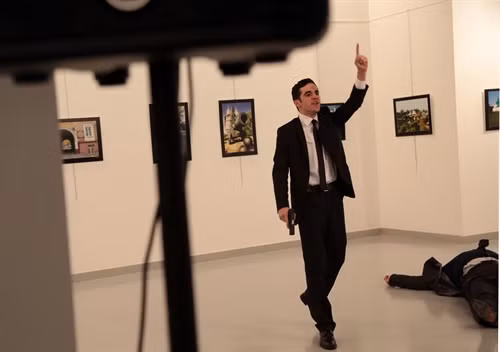Hung thủ Mevlut Mert Altintas (trái) sau khi sát hại Đại sứ Nga Andrei Karlov tại trung tâm nghệ thuật ở Ankara ngày 19/12. AP/ TTXVN