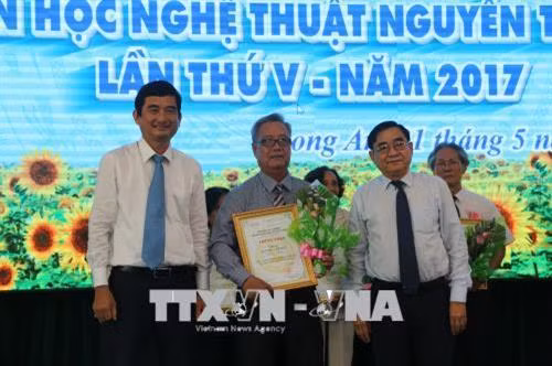 Phó Bí thư Tỉnh ủy Đỗ Hữu Lâm và Phó Chủ tịch UBND Long An Phạm Văn Cảnh, trao giải thưởng cho các tác giả đạt giải. Ảnh: Trần Thanh Bình-TTXVN
