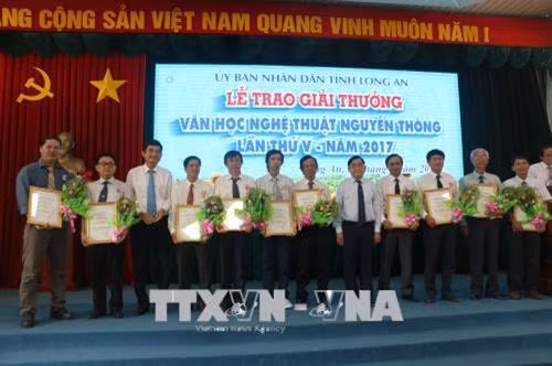 Phó Bí thư Tỉnh ủy Đỗ Hữu Lâm và Phó Chủ tịch UBND Long An Phạm Văn Cảnh, trao giải thưởng cho các tác giả đạt giải. Ảnh: Trần Thanh Bình-TTXVN