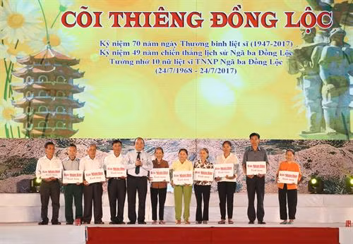 Thủ tướng Nguyễn Xuân Phúc trao sổ tiết kiệm cho thân nhân 10 nữ liệt sĩ Thanh niên xung phong Ngã ba Đồng Lộc. Ảnh: Thống Nhất-TTXVN