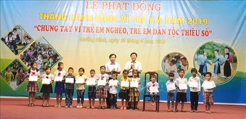 Tặng quà cho trẻ em có hoàn cảnh đặc biệt khó khăn, trẻ em dân tộc và trẻ khuyết tật trên địa bàn huyện Quảng Ninh. Ảnh: Võ Dung-TTXVN