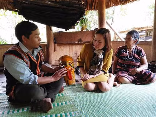 Nghệ nhân Alăng Blêu giới thiệu phù điêu mặt thần Rapây. Ảnh: baoquangnam.vn