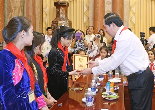 Chủ tịch nước Trần Đại Quang tặng chân dung Chủ tịch Hồ Chí Minh cho các các thiếu nhi. Ảnh: Nhan Sáng-TTXVN