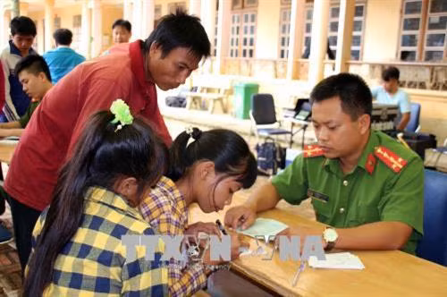 Công an tỉnh Sơn La hướng dẫn người dân làm thủ tục cấp phát chứng minh thư nhân dân. Ảnh: Diệp Anh - TTXVN