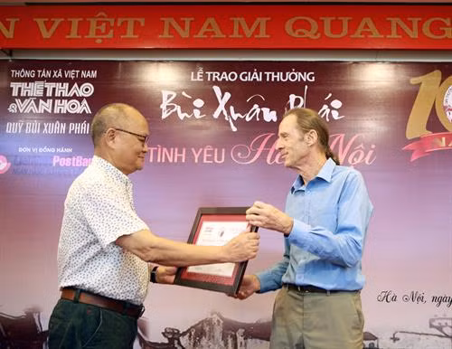 Giải "Việc làm – Vì tình yêu Hà Nội" được trao cho ông Paul George Harding (cựu chiến binh Mỹ, bên phải) về việc xóa quảng cáo rao vặt và làm sạch các con ngõ, truyền cảm hứng mạnh mẽ trong cộng đồng để giữ gìn vẻ đẹp Hà Nội. Ảnh: Hoàng Hùng - TTXVN