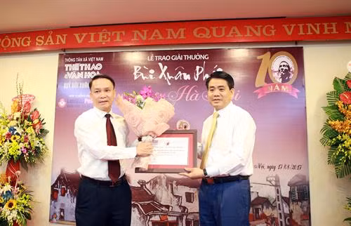 Ông Nguyễn Đức Chung (bên phải), Chủ tịch UBND TP Hà Nội, đại diện UBND Thành phố nhận giải "Việc làm – Vì tình yêu Hà Nội" về việc xây dựng Phố đi bộ khu vực Hồ Gươm. Ảnh: Hoàng Hùng - TTXVN