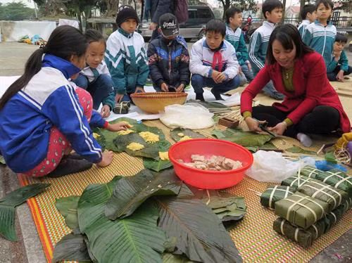 Các em thiếu nhi cũng được tham gia học và gói bánh chưng. Ảnh: Lâm Khánh - TTXVN