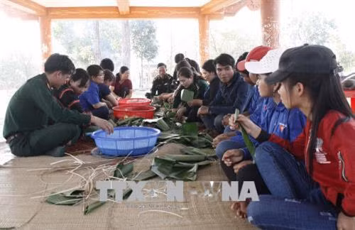 Các thành viên Bộ đội biên phòng, Hội Liên hiệp phụ nữ và Đoàn Thanh niên tỉnh Gia Lai gói bánh chưng tặng bà con vùng biên giới Ia Mơ. Ảnh: Hoài Nam – TTXVN