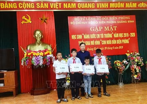 Phó Chủ tịch UBND tỉnh Quảng Bình Nguyễn Tiến Hoàng trao tặng quà của Bộ Tư lệnh Bộ đội Biên phòng cho các học sinh. Ảnh: Võ Dung-TTXVN