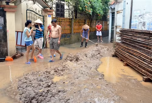 Người dân khu 7b, phường Hồng Hải, Tp Hạ Long khẩn trương thu dọn bùn đất trôi từ dự án xuống (Nguyễn Hoàng-TTXVN)