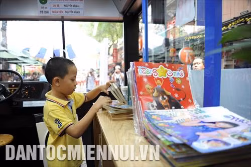Các em nhỏ thích thú đọc sách trên xe buýt sách